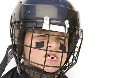 a child with a helmet and knocked out teeth