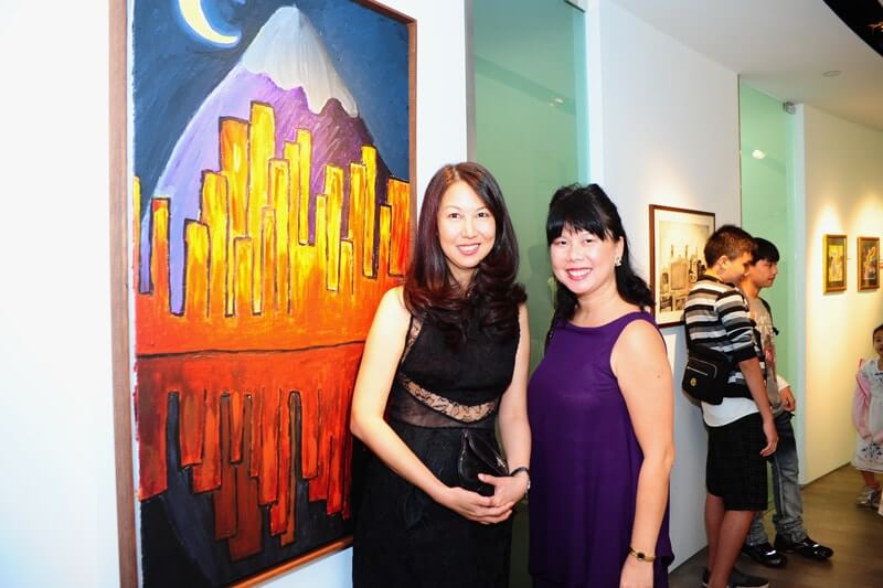 CHARITY ART EXHIBITION - 2 person taking photo beside an art piece