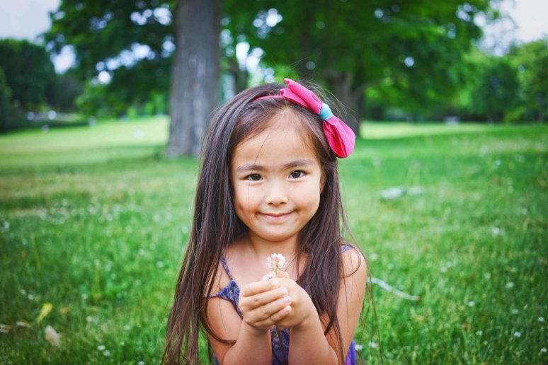 a girl holding a flower in her hand