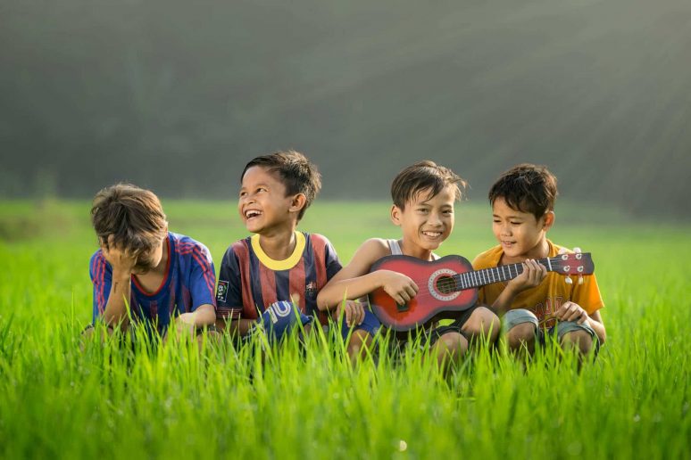 4 boys sitting on the grass