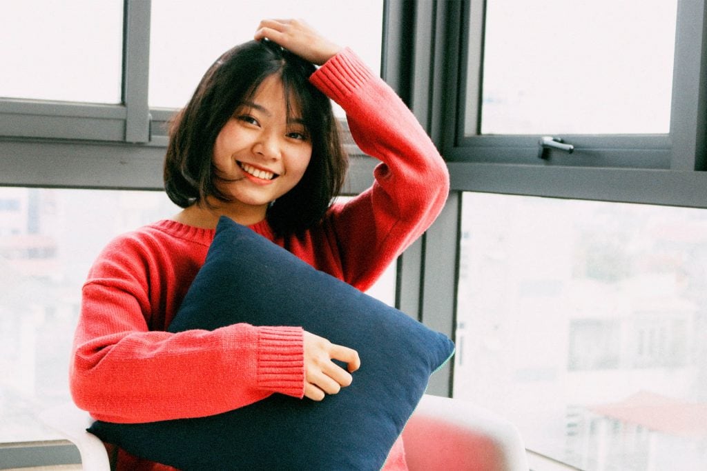 a women scratching her head and smiling for the camera