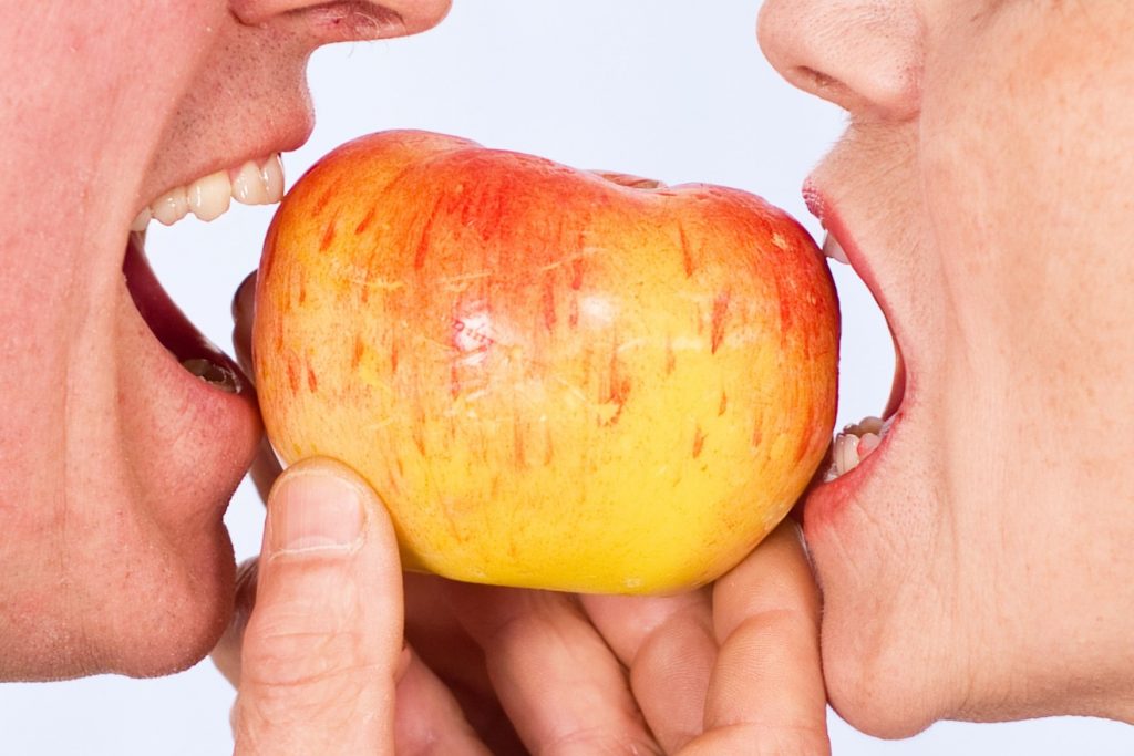 two elderly biting the apple