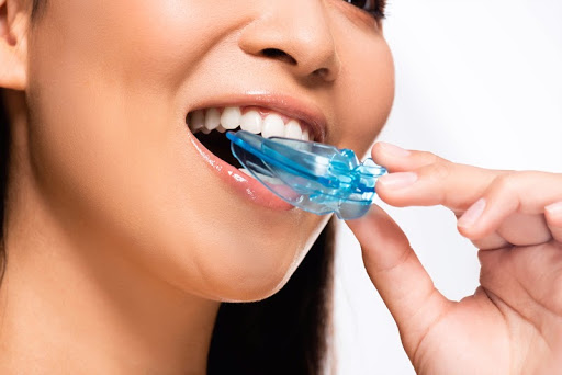 woman using a mouth guard to cure teeth grinding